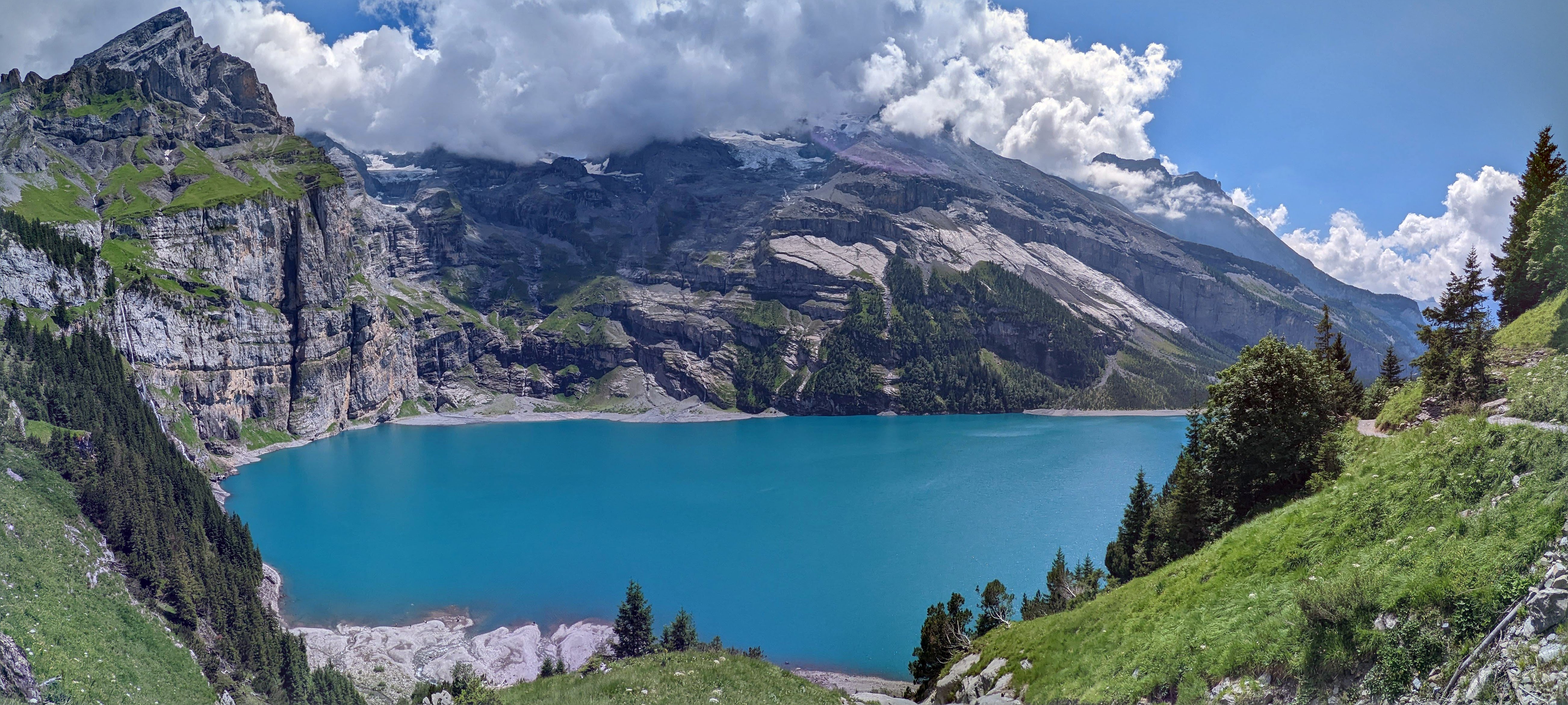 Blauw bergmeer tussen groene hellingen in de Zwitserse Alpen